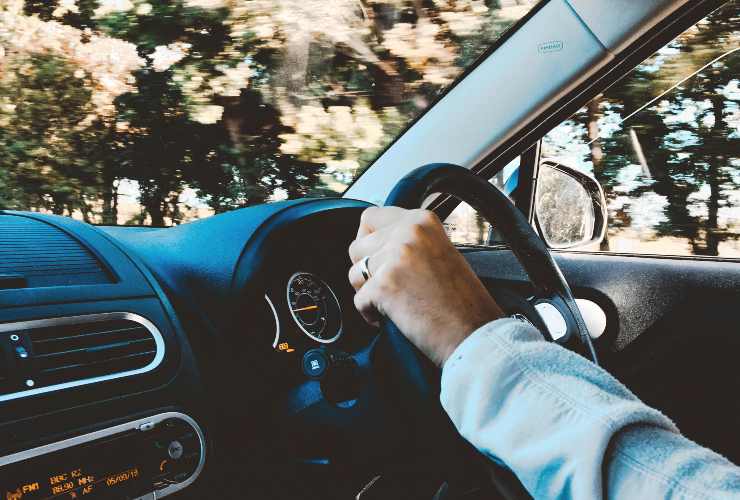 Giovane uomo con la mano sinistra sul volante - foto Pexels - LaGazzettadelSerchio.it