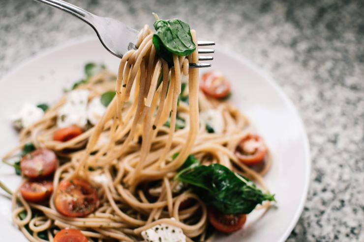 Piatto di spaghetti con pomodoro, rucola e feta - foto Pexels - Lagazzettadelserchio.it